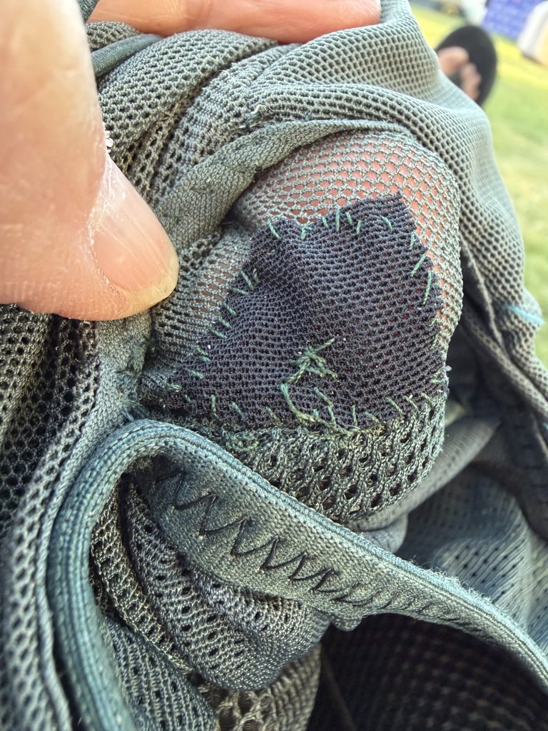 A hole that has been patched on a hydration pack.